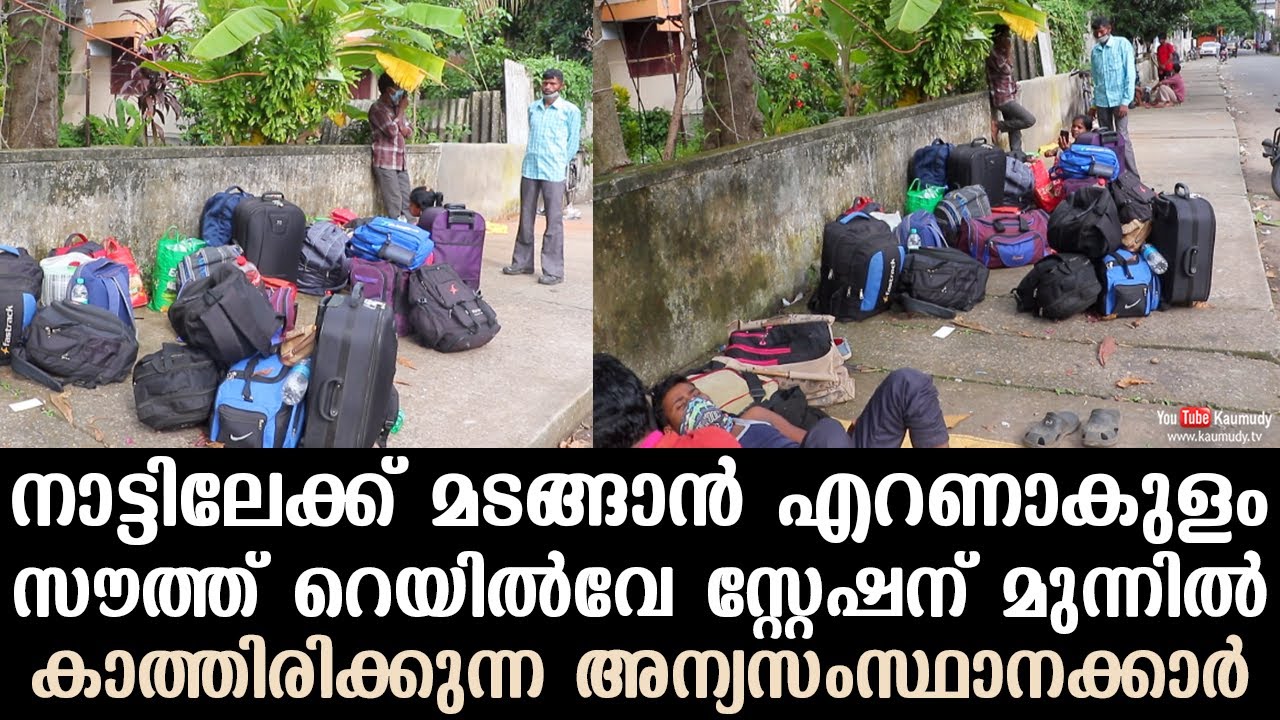 Migrant workers wait in front of Ernakulam south railway station to ...