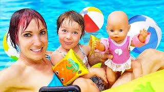 Lapset leikkivät nukeilla ja uivat vesipuistossa. Baby Annabell nukke uimaaltaassa ja porealtaassa