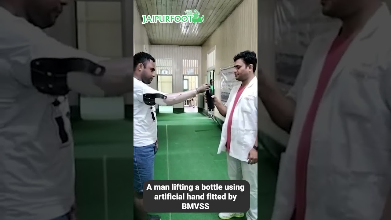 A man lifts a water bottle with ease using an artificial hand provided by BMVSS.