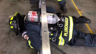 Firefighter fits through a ladder with an SCBA