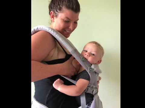 breastfeeding newborn in ergo baby carrier