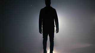 silhouette of man is walking through smoky studio