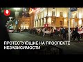 Колонна людей с флагами на проспекте Независимости вечером 26 октября