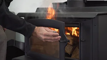 Why does smoke come into the room when I open the wood burner door?