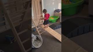 Boy walks up wooden slide then loses his balance and faceplants on the ground