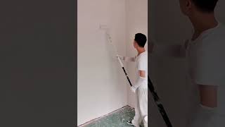 Painting interior wall white using long roller tool