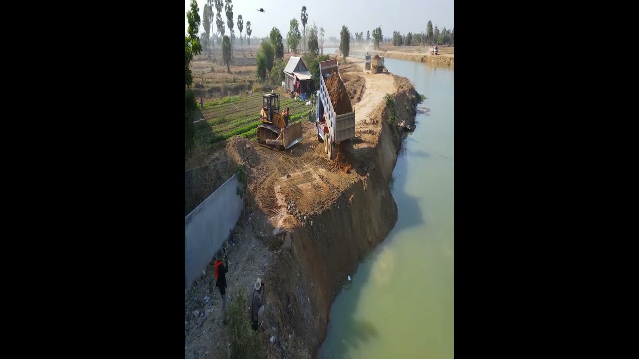 Unstoppable Reinforcement: D60P Dozer Crushes Rock Under Endless Truck Deliveries