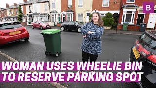 Woman uses wheelie bin to reserve parking spot on busy street
