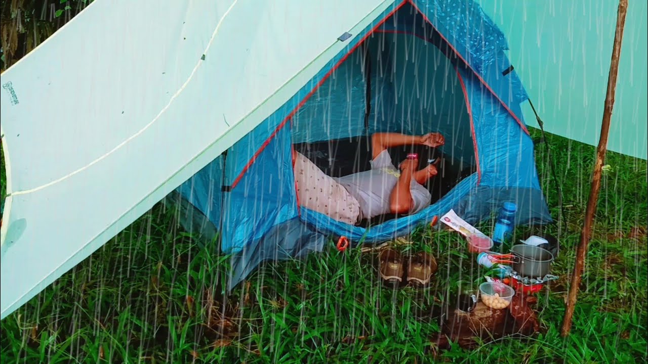 solo camping in the forest when it rains heavily, setting up a