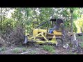 John Deere 450c sifting through burn pile.