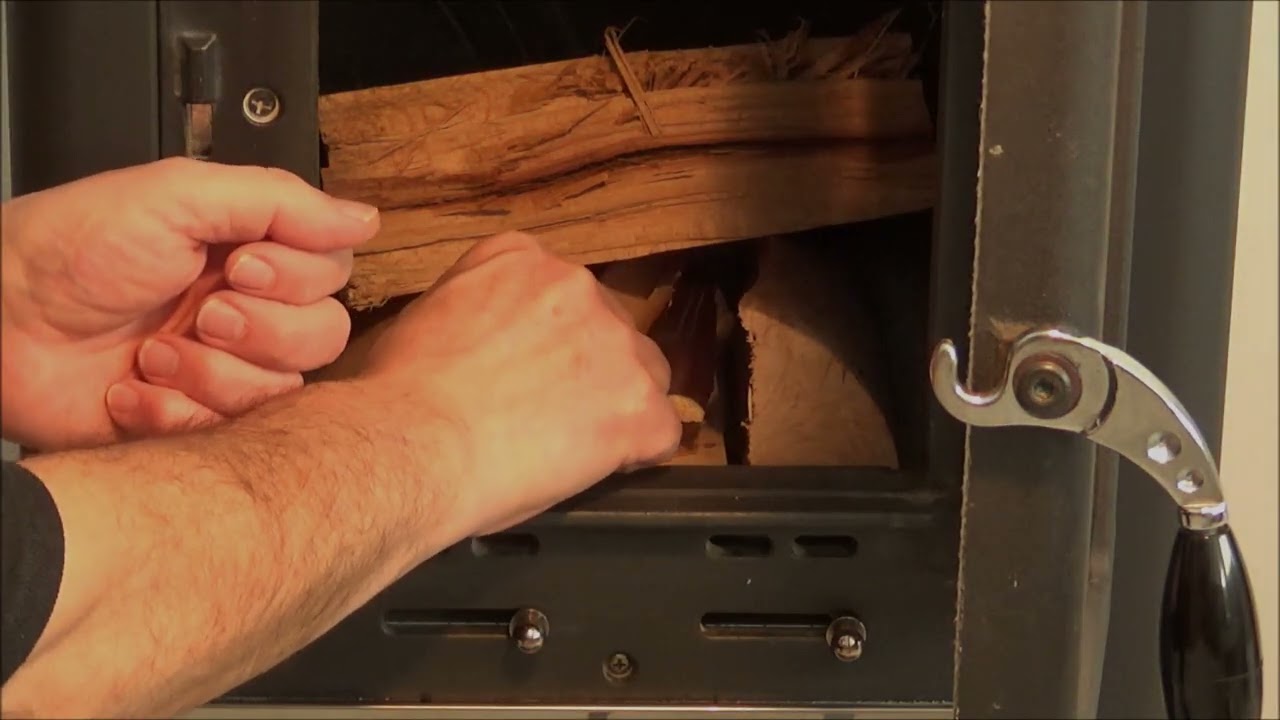 Nalaganje bukovih drv brez skorje, dolžina polen 25 cm v kurišče kaminske peči i prižiganje