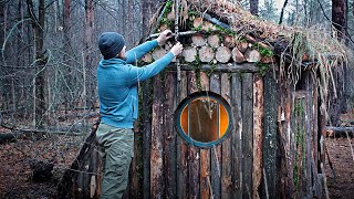 A man builds a log cabin in the forest. Shelter made of logs. Part 10