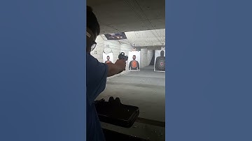 firing a Masada 9mm pistol with red dot
