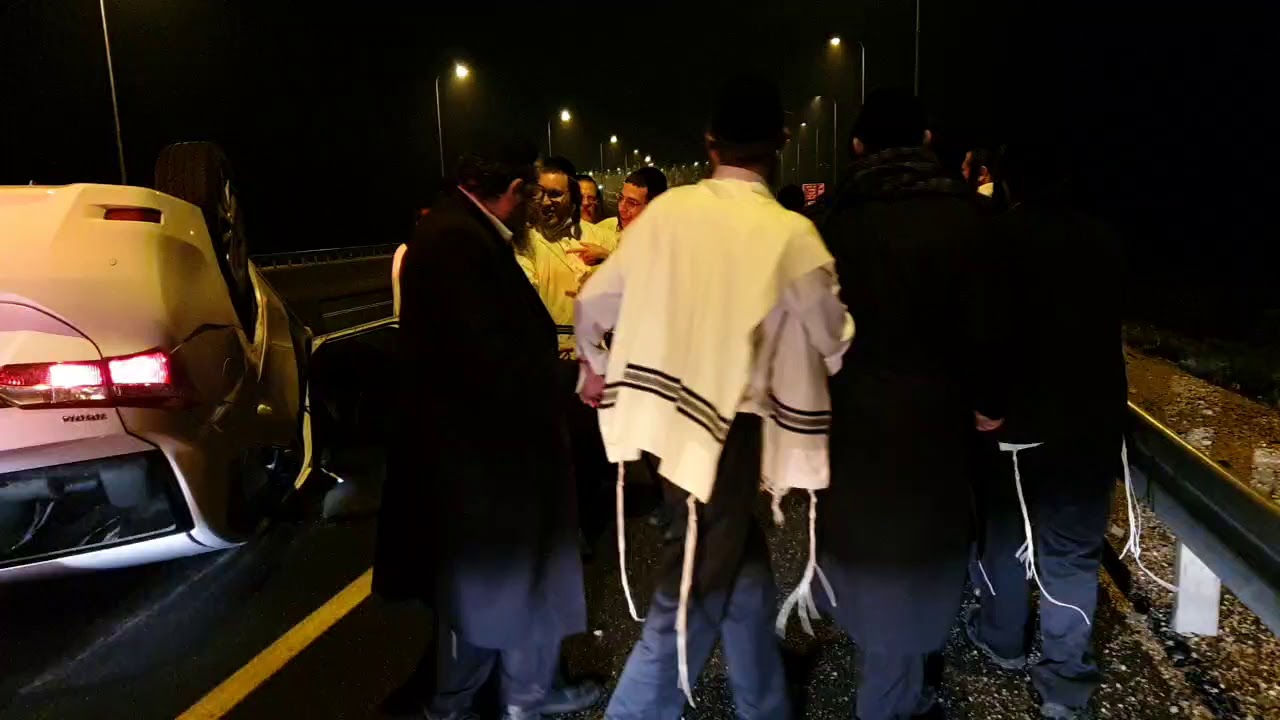 החסידים רוקדים ליד הרכב ההפוך