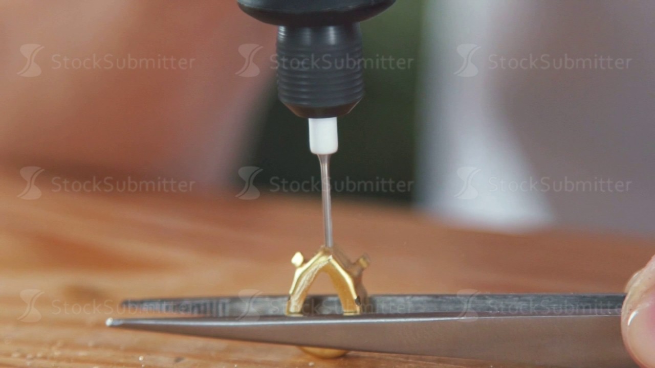 Closeup jewelry drill bores a hole in the metal part. Forceps Jeweler