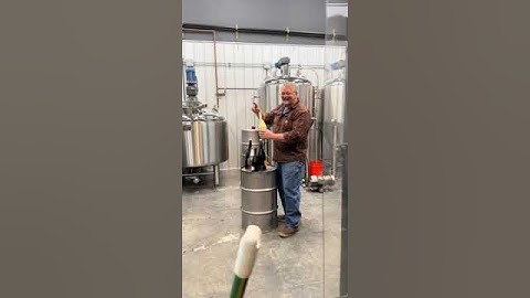 Man Opens Bottle of Sparkling Wine Making it Shoot Onto Distillery Wall -  1498011