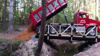 David perfectly backs his dump truck onto a residential driveway bridge.