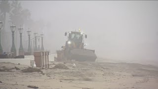 City crews clean up boardwalk after big waves crash over beach wall in Mission Beach