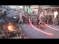 Very skilled and hardworking men manufacturing iron bars in a factory