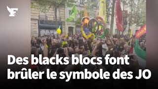 1er-Mai: à l'avant du cortège des blacks blocs font brûler le symbole des JO