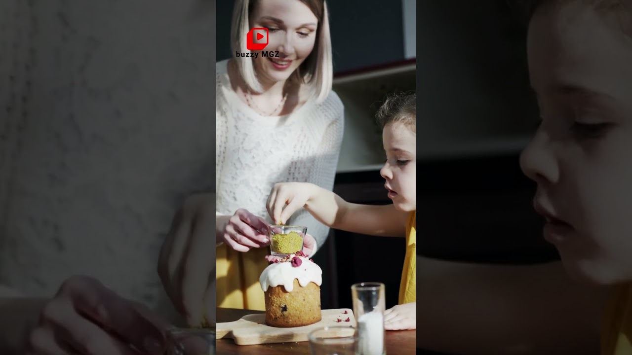 A Young Girl Sprinkle Topping On A Cake Guided By Her Mother 
