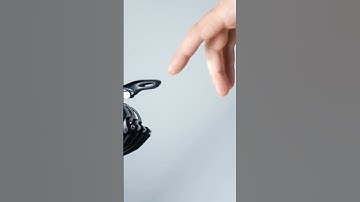a human hand touching prosthetic arm
