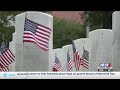 Volunteers place flags at Biloxi National Cemetery ahead of Memorial Day
