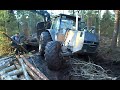 Valtra forestry tractor stuck in mud with big trailer in wet forest