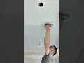 white material onto the ceiling surface for a flat finish during home renovation work