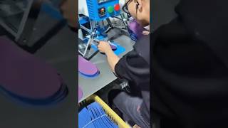 stamping small purple fabric insoles using a blue industrial heat press machine inside the factory
