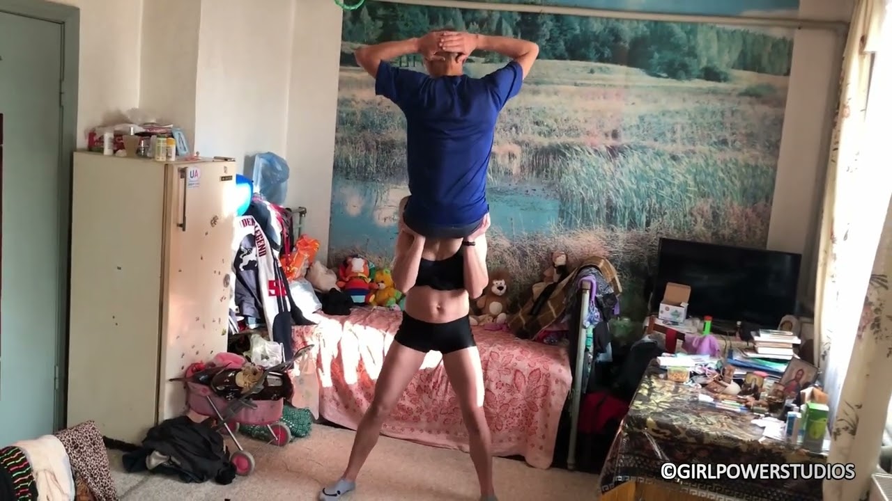 Strong girl lifts an old man