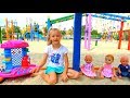 Funny Polina playing with Colored cups and baby dolls on the playground