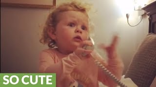 Sweet little girl adorably rambles on the telephone