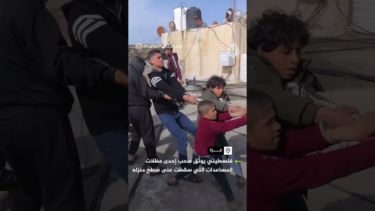 فلسطيني يوثق سحب إحدى مظلات المساعدات سقطت على سطح منزله