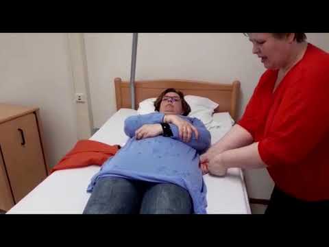 Instructie glijzeil en aankleden op bed bij een cliënt met halfzijdige verlamming