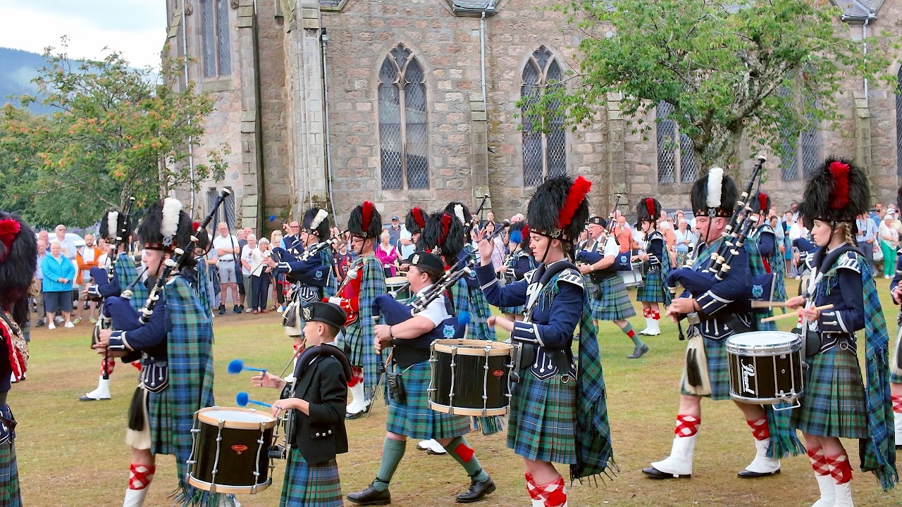 Drum Majors lead Ballater Pipe Band playing Caber Feidh at Beating Retreat after 2025 Highland Games
