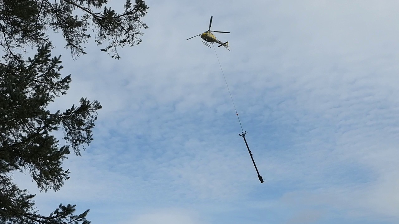 Helicopter transporting transmission line poles and equipment during a power upgrade 🚁⚡