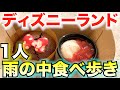 雨の中1人でディズニーランドを食べ歩きする男