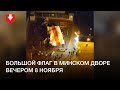 Люди вынесли большой флаг во двор на улице Червякова в Минке