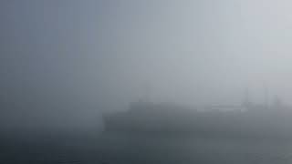 Submarine tender USS Emory S Land in thick fog.