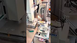 Automated needle stitches green strip—rollers guide rhythm of fabric, thread, and precision seam.