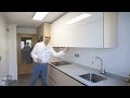 Video de cocinas blancas  modernas con madera estilo nordico perfil gola y encimera de silestone