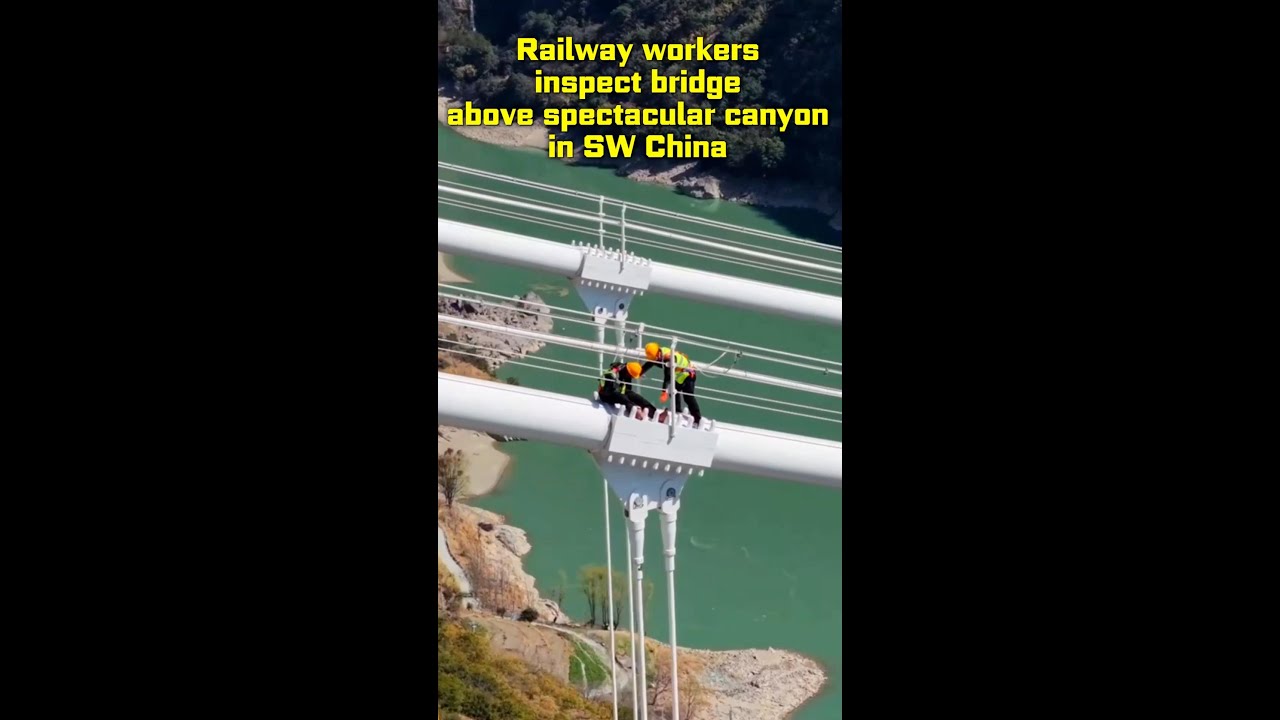 Railway workers inspect bridge above spectacular canyon in SW China