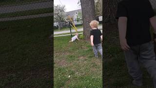 Kids playing outside together. Baby crawling, toddler fighting with sticks.