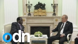 Putin and Mugabe make jokes about sanctions at a meeting in Russia