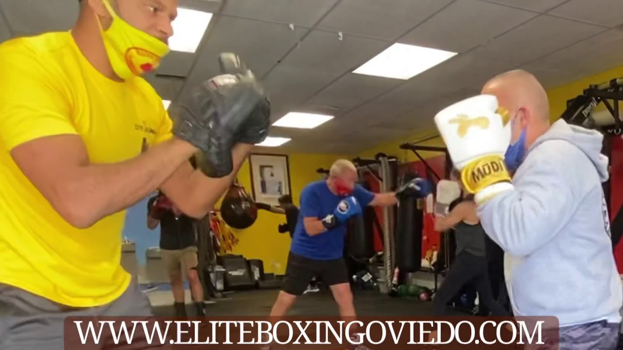 Working the focus mitts in a boxing class. Learn to box in Oviedo