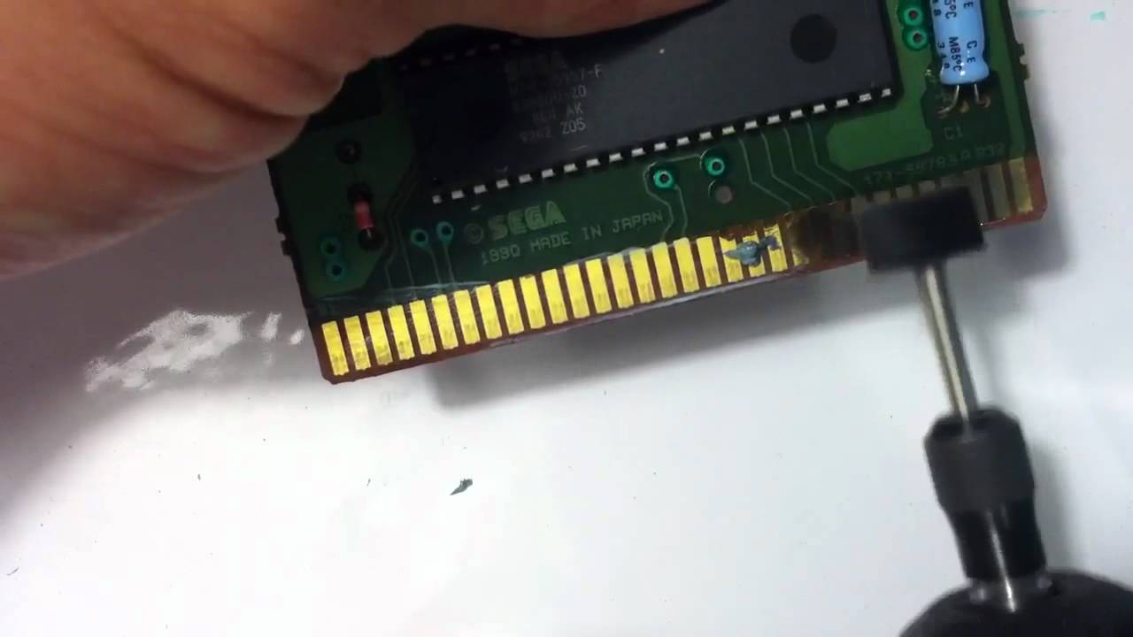 Professionally cleaning a Sega Genesis game.