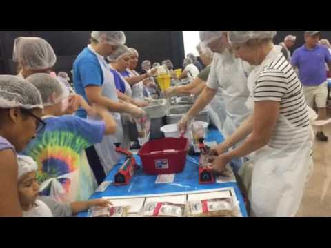 newspaper Volunteers filling oatmeal bags for Feed the Need.