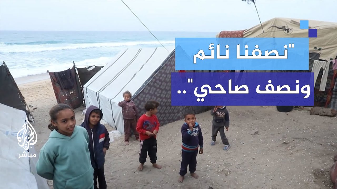 نازحون يتشاركون الأغطية في خيامهم على شاطئ البحر لأنها لا تكفيهم