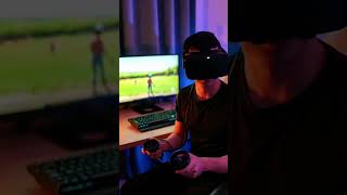 A person in a VR headset interacts with controllers in a dimly lit room with tech equipment.